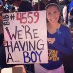 As her husband, Jim, finished the Boston Marathon, Sarah Norcott held this sign telling him the sex of the baby they are expecting. 